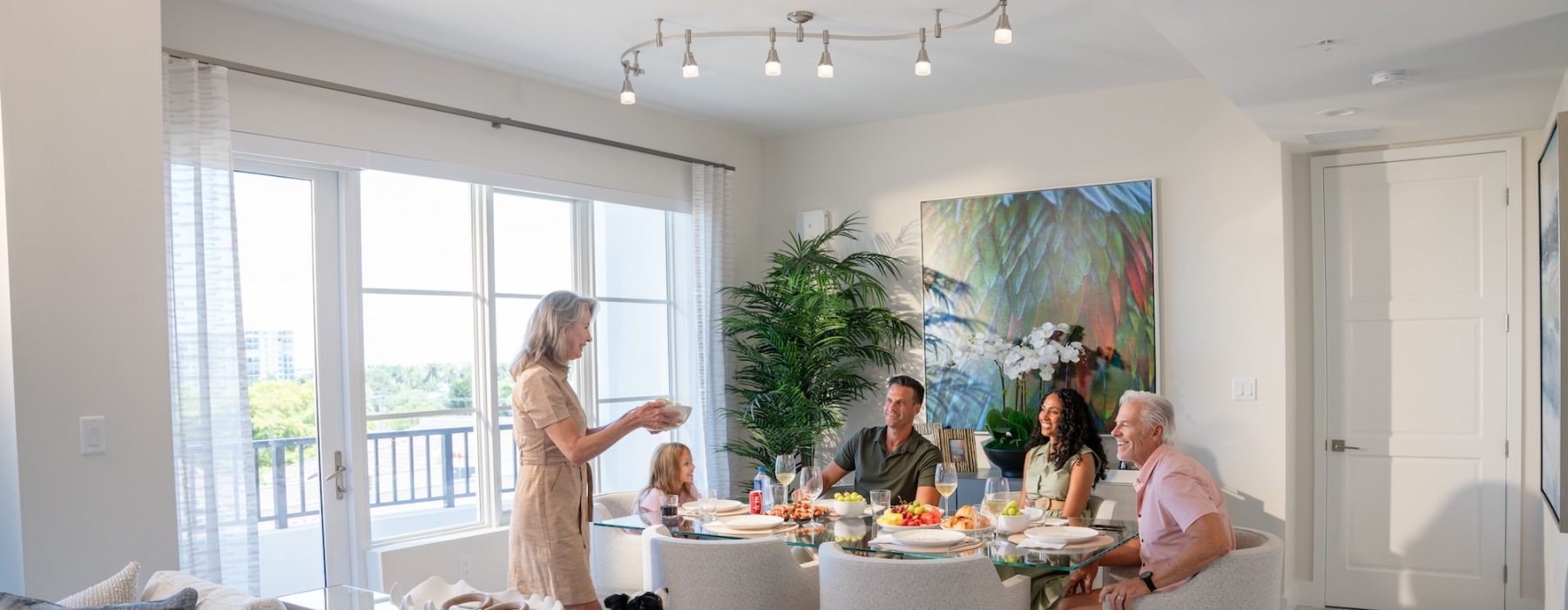 a family having dinner is a well-lit room
